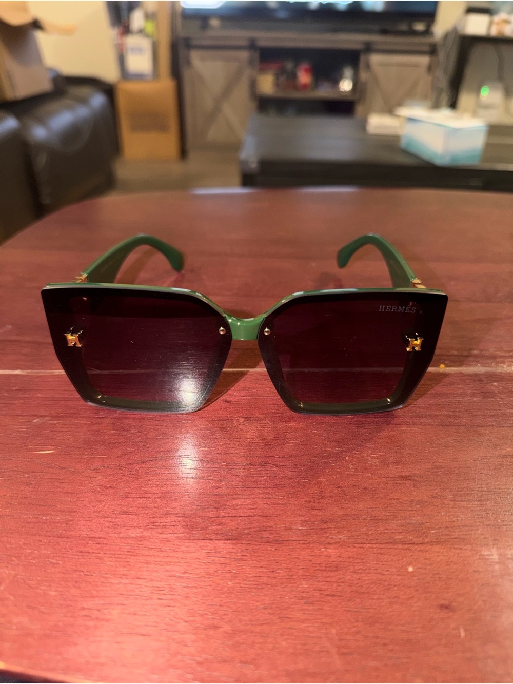 Green Hermes sunglasses with gold accents
